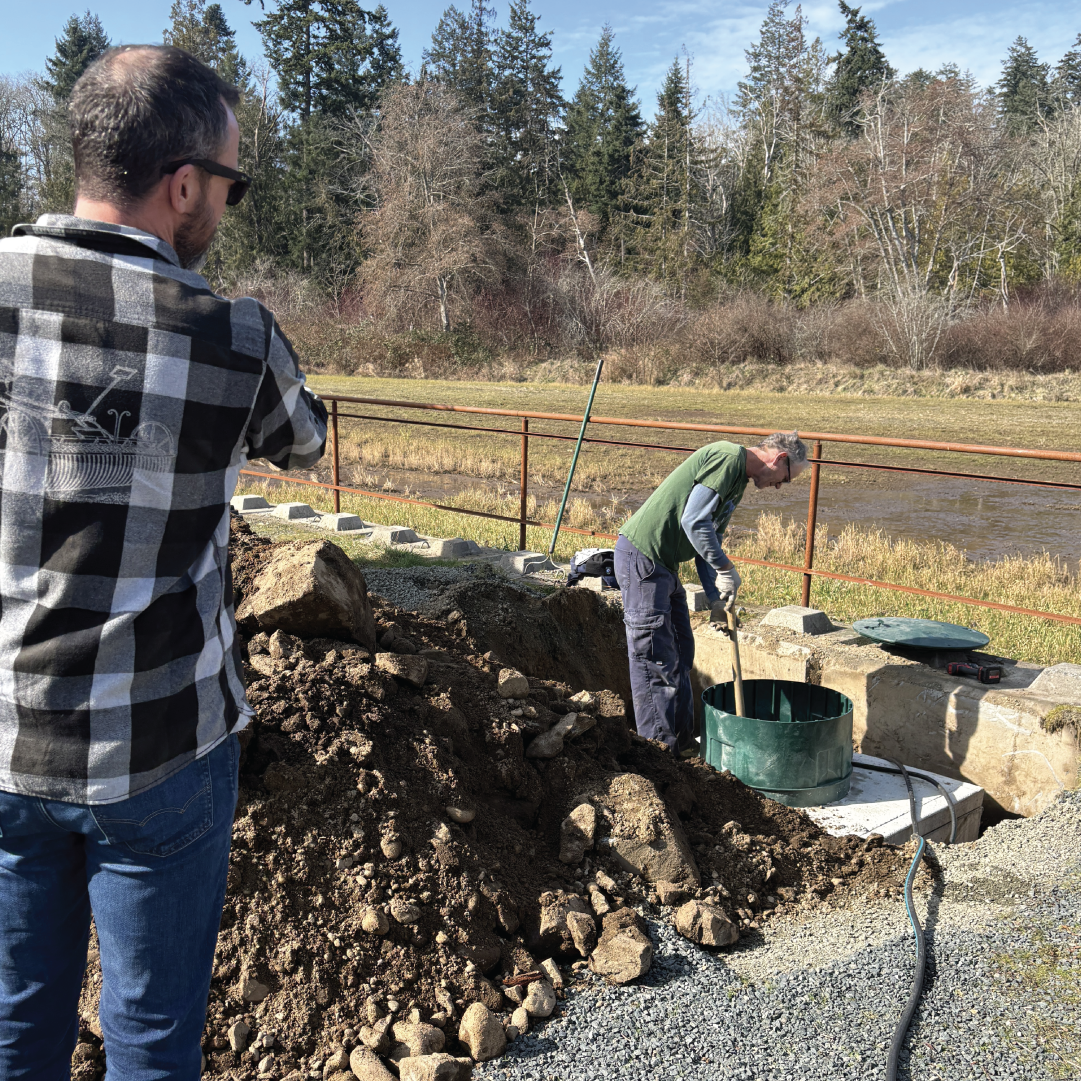 Farmer Will digging an irrigation channel at Rusted Rake Brewing to reuse brewery runoff water for compost and sustainable farming in Nanoose Bay